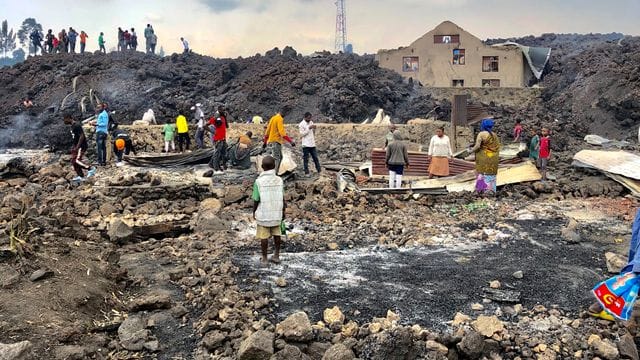 Menschen versammeln sich an einem Strom aus kaltem Lavagestein nach dem nächtlichen Ausbruch des Mount Nyiragongo in Goma.