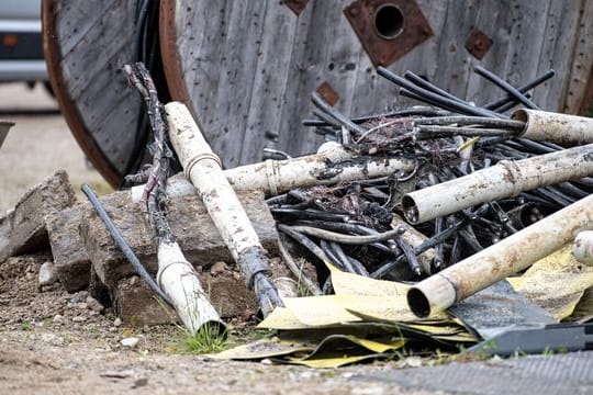 Beschädigte Stromkabel liegen neben einer Baustelle, an der ein Kabelbrand ausgebrochen war.