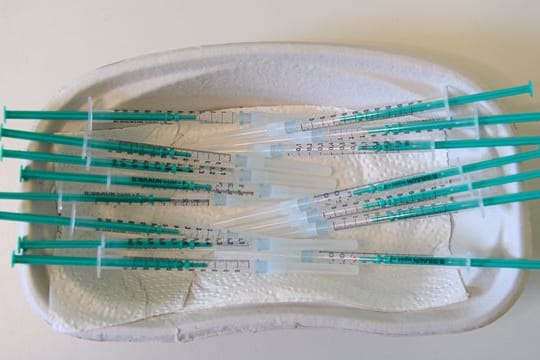 Spritzen mit dem Wirkstoff Comirnaty von Biontech/Pfizer gegen das Coronavirus in einer Hausarztpraxis.