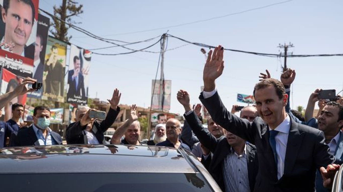 Baschar al-Assad (r), Präsident von Syrien, kommt an einem Wahllokal während der Präsidentschaftswahlen an.