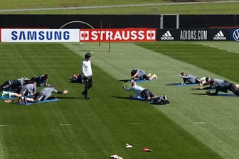 Bundestrainer Joachim Löw (M) steht bei der Erwärmung ohne Ball zwischen den Spielern.