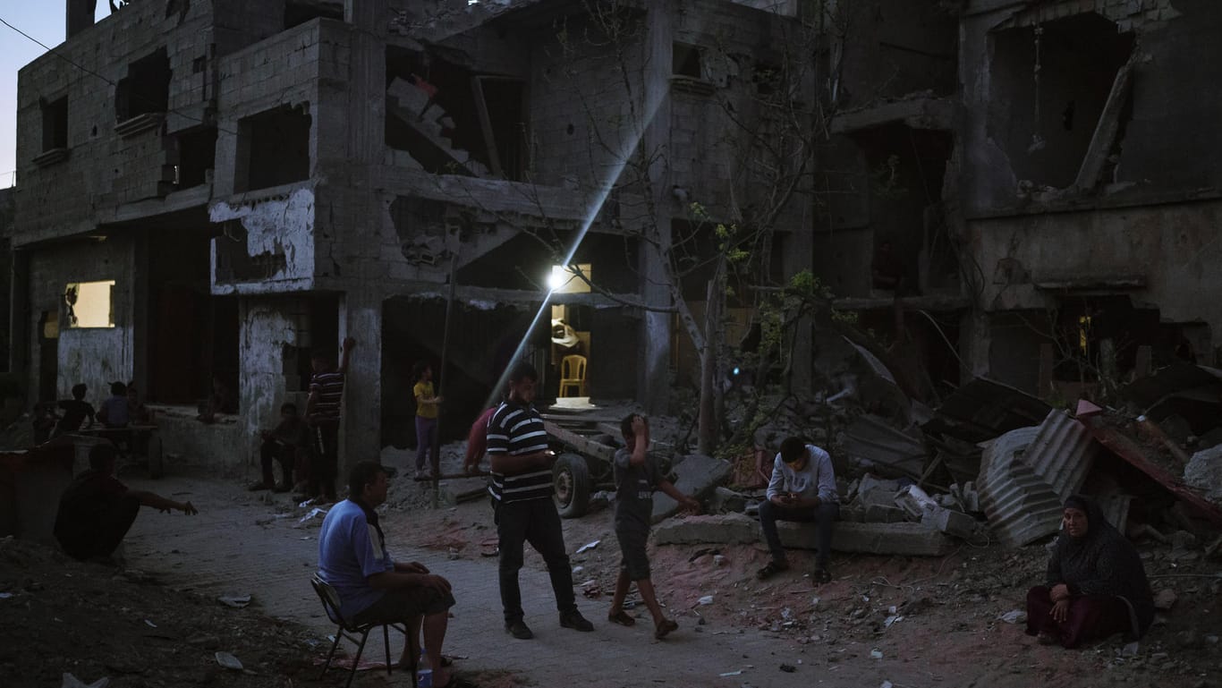 Menschen vor zerbombten Häusern im Gazastreifen: Mehr als elf Tage lieferten sich militante Palästinenser und Israel einen heftigen Beschuss.