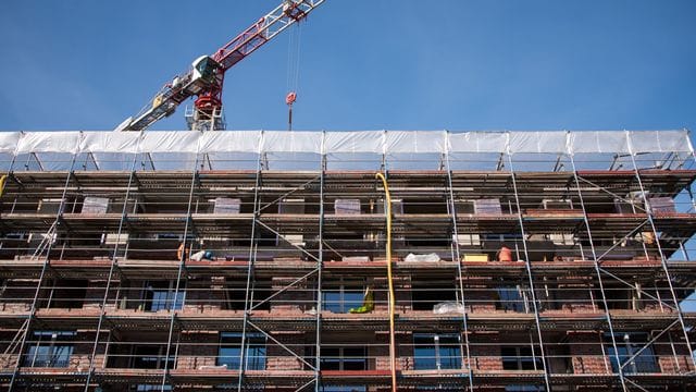 Ein Gerüst ist auf einer Baustelle an einem Neubau angebracht Ein Gerüst ist auf einer Baustelle an einem Neubau angebracht