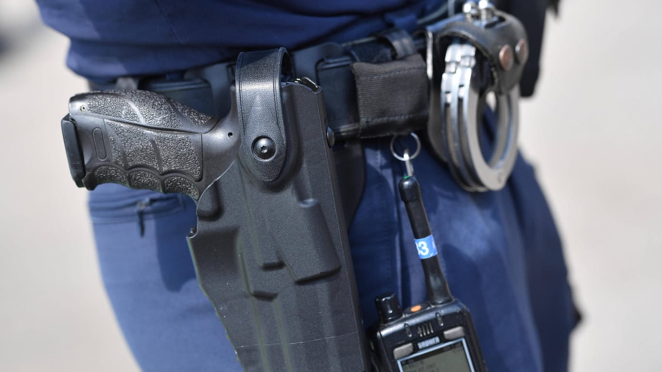 Handschellen und Pistole am Gürtel eines Polizisten (Symbolbild): Bei Karlsruhe ist ein junger Mann nach einem Banküberfall gefasst worden.