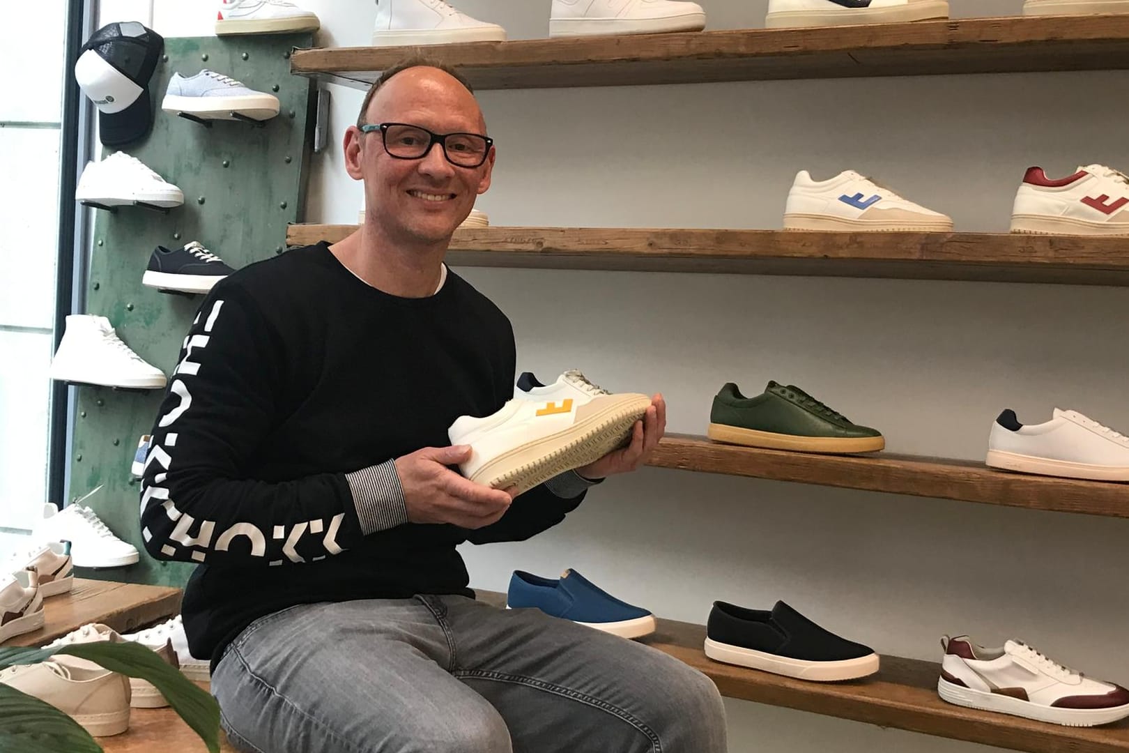 Christian Ohm hält einen seiner nachhaltigen Sneaker in der Hand: Er setzte seine Idee während der Pandemie in die Tat um.