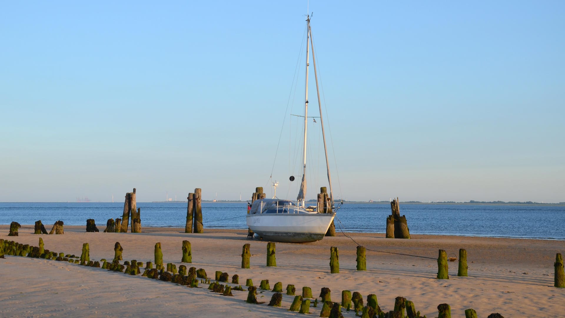 Das Wasser hat sich zurückgezogen: In Ostende auf Wangerooge liegt ein Boot bei Ebbe auf dem Wattboden.