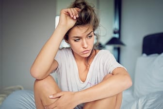 Bedrückt wirkende junge Frau: Wenn eine bakteriellen Vaginose zu einem fischig riechenden Scheidenausfluss führt, ist das den betroffenen Frauen oft sehr unangenehm.
