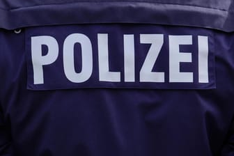 Auf einer Uniform steht der Schriftzug "Polzei" (Symbolbild): Die mutmaßichen Betrüger haben sich unter einem Vorwand Zugang zu Wohnungen verschafft.