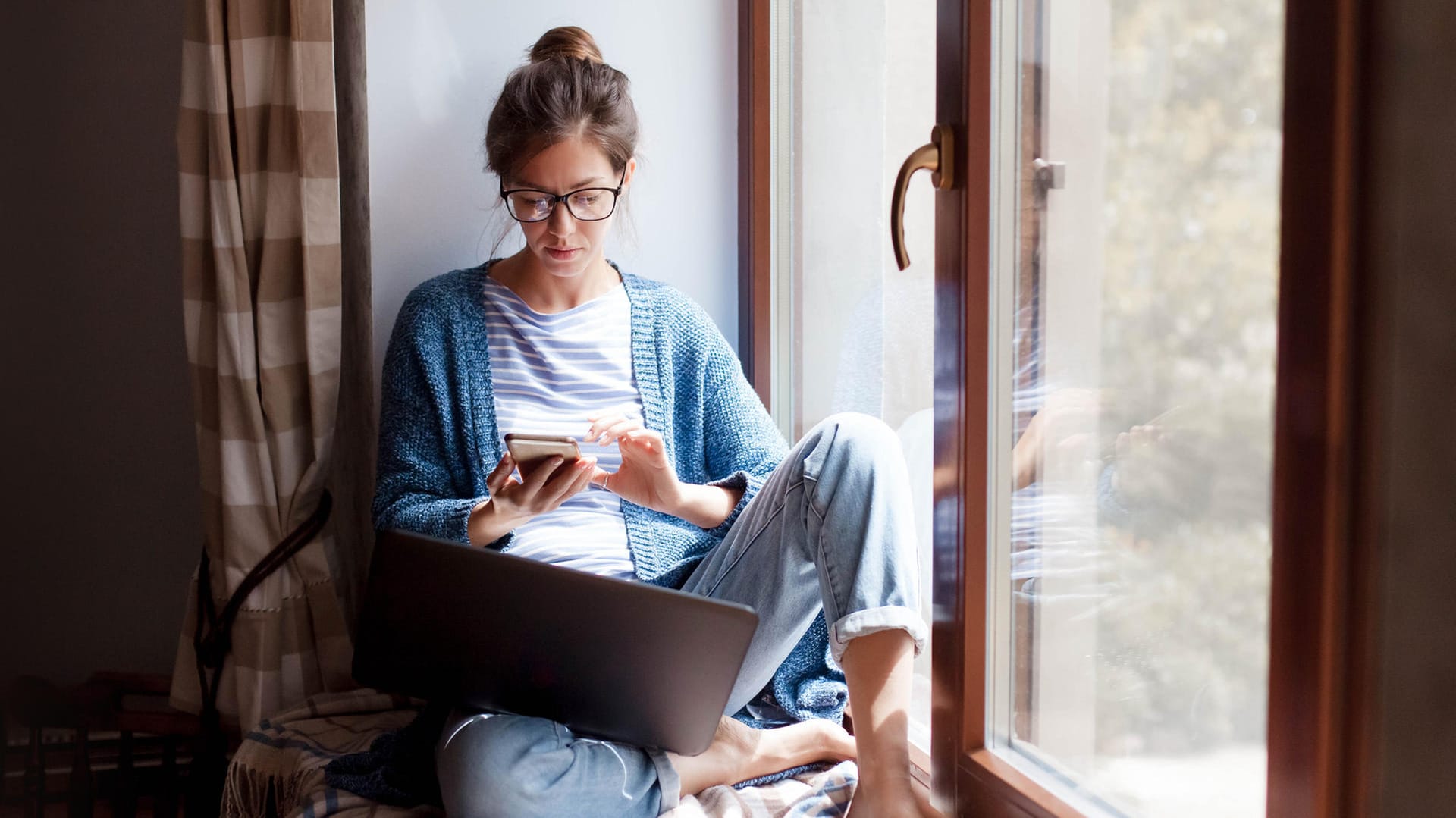 Eine Frau am Smartphone (Symbolbild): Einem Disagio können Sie zum Beispiel bei der Baufinanzierung begegnen.