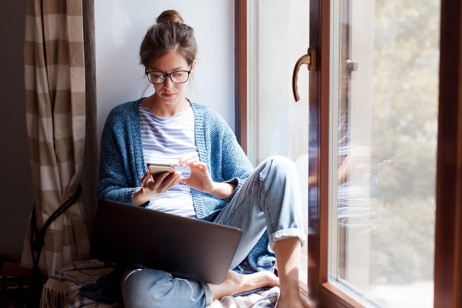 Eine Frau am Smartphone (Symbolbild): Einem Disagio können Sie zum Beispiel bei der Baufinanzierung begegnen.