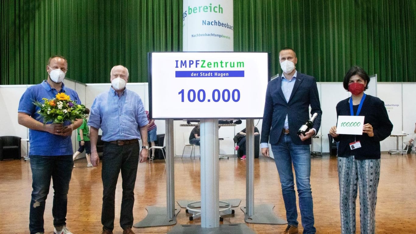 Klaus Behnke (2.v.l.) wird von den Verantwortlichen im Impfzentrum in Empfang genommen: Er hat die 100.000. Impfung in der umfunktionierten Stadthalle bekommen.