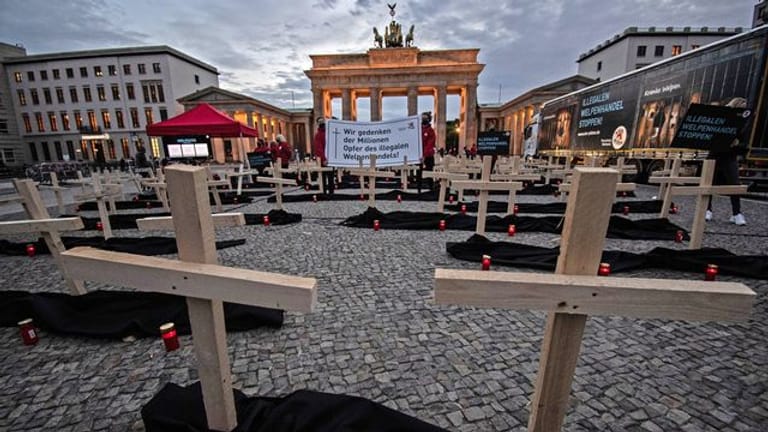 Zahlreiche Holzkreuze und Grablichter stehen auf dem Pariser Platz vor dem Brandenburger Tor: Die Stiftung Tierschutz "Vier Pfoten" hat eine Mahnwache abgehalten.