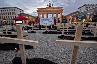 Zahlreiche Holzkreuze und Grablichter stehen auf dem Pariser Platz vor dem Brandenburger Tor: Die Stiftung Tierschutz "Vier Pfoten" hat eine Mahnwache abgehalten.
