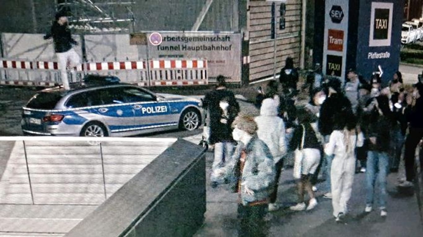 Das Standbild einer Überwachungskamera zeigt einen tanzenden Mann auf einem parkenden Polizeiauto: Der Mann wurde angezeigt.