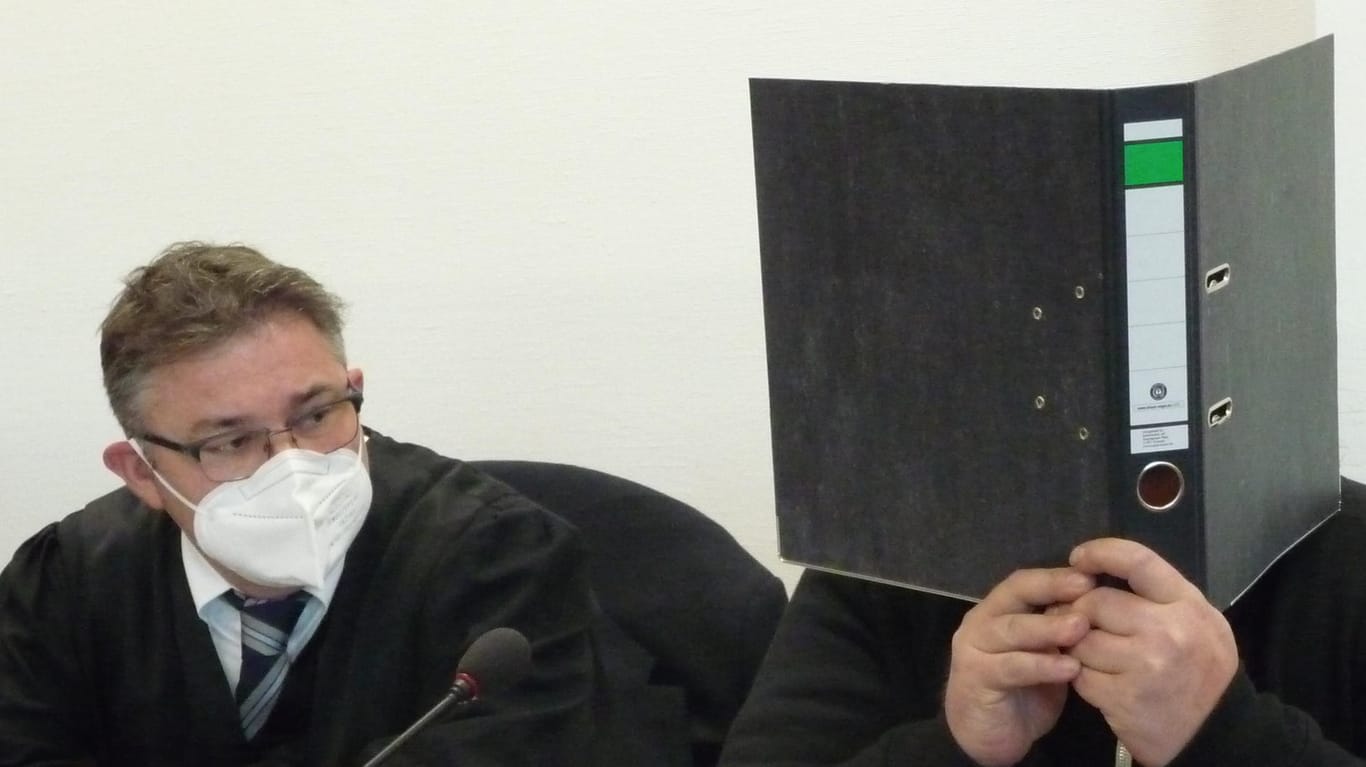 Der Angeklagte, hier neben seinem Verteidiger Dr. Peter-René Gülpen, versteckte sich vor Prozessbeginn hinter einem Aktenordner.
