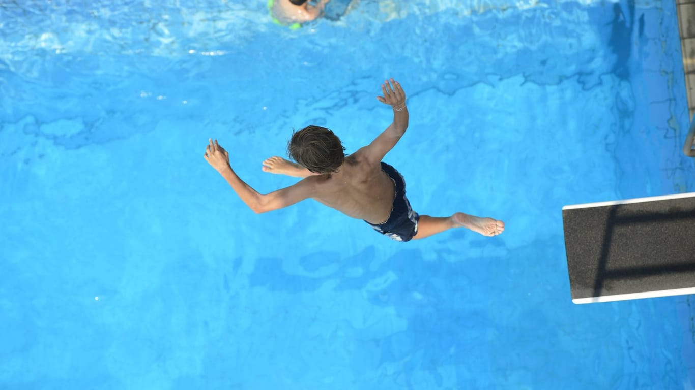 Ein Junge springt ins Schwimmbecken (Symbolbild): Ab Sonntag sollen die meisten Kölner Freibäder wieder öffnen.