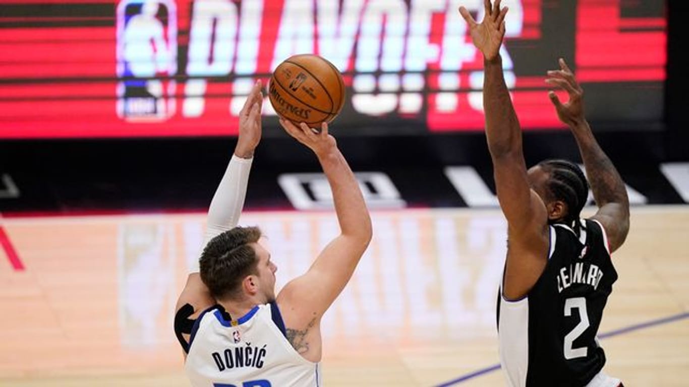 Luka Doncic (l) von den Dallas Mavericks wirft über Clippers-Starspieler Kawhi Leonard.
