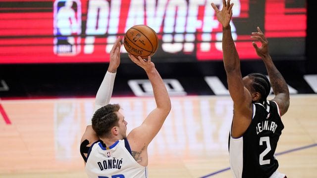 Luka Doncic (l) von den Dallas Mavericks wirft über Clippers-Starspieler Kawhi Leonard.