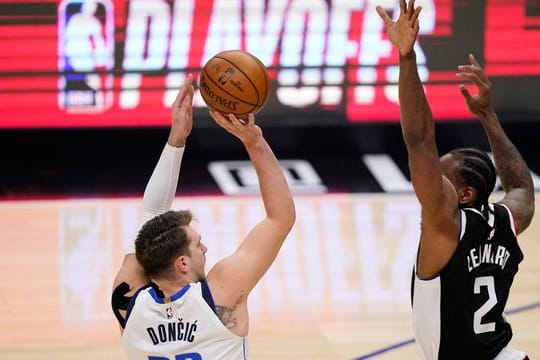 Luka Doncic (l) von den Dallas Mavericks wirft über Clippers-Starspieler Kawhi Leonard.