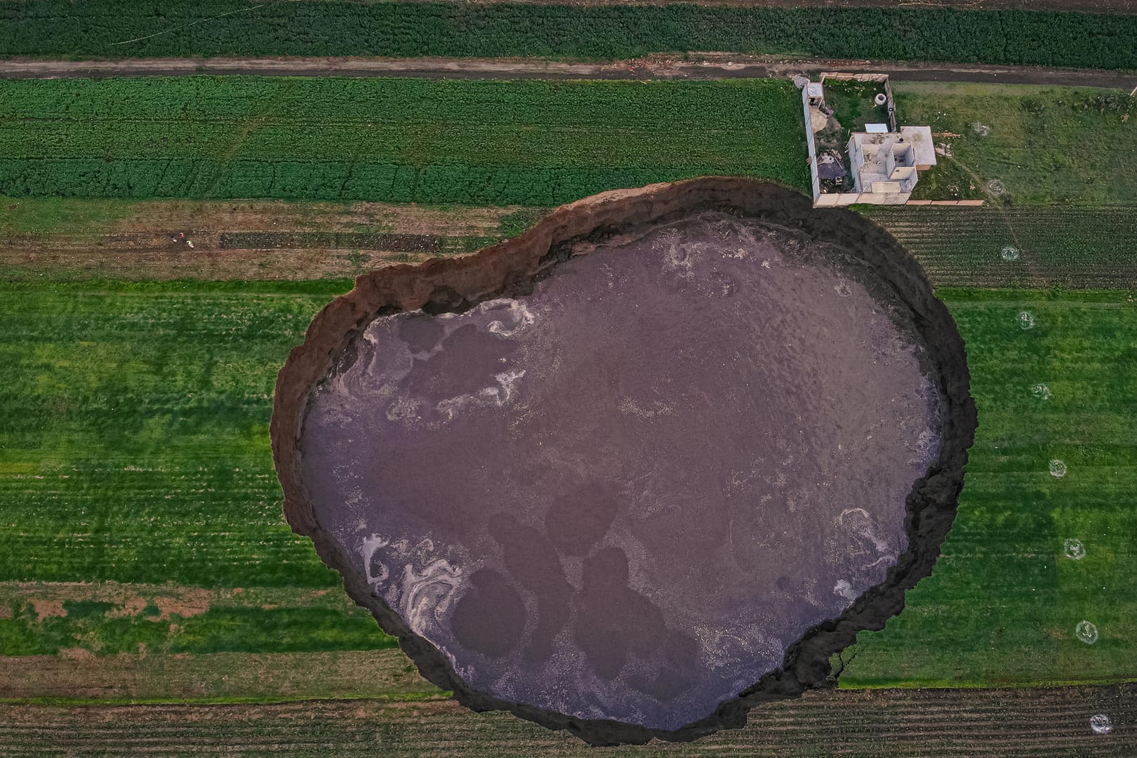 Mexiko, Santa Maria Zacatepec: Aus der Vogelperspektive ist ein großer mit Wasser gefüllter Krater zu sehen.