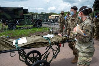 US-Soldaten schieben eine Trage mit einer Puppe