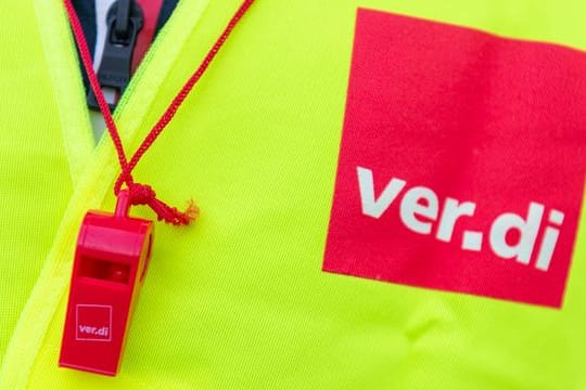 Ein Streikender trägt eine Warnweste mit dem Verdi-Logo
