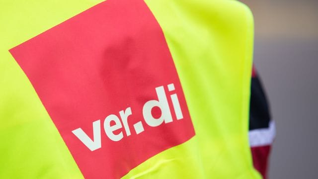 Ein Demonstrant hat eine Warnweste mit der Aufschrift "ver.di" an