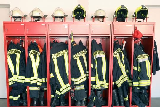 Ein Schrank mit Jacken und Helmen einer Freiwilligen Feuerwehr (Symbolbild): Bei der Bremer Feuerwehr waren rassistische Chats aufgetaucht.