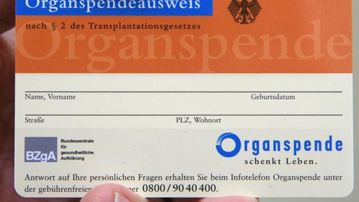 Ein Mann hält einen Organspendeausweis