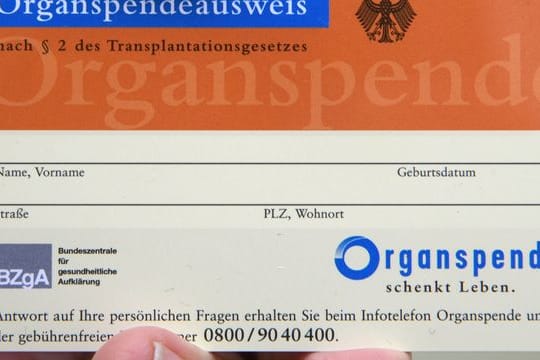 Ein Mann hält einen Organspendeausweis