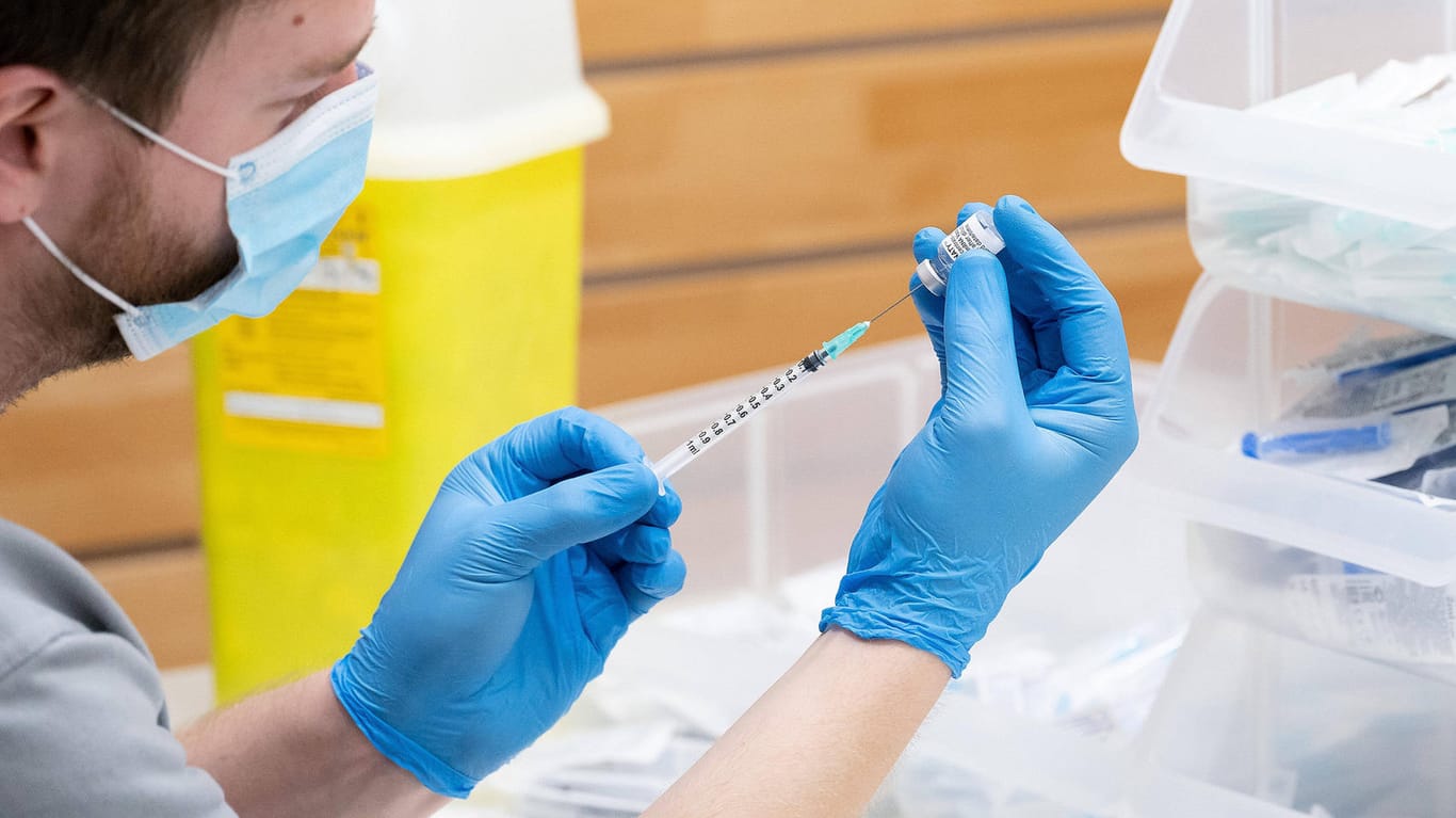 Ein Helfer zieht in einem Impfzentrum in Niedersachsen eine Biontech-Spritze auf: Mit einer speziellen Spritze lassen sich aus einer Ampulle des Stoffes sieben statt nur sechs Dosen aufziehen.