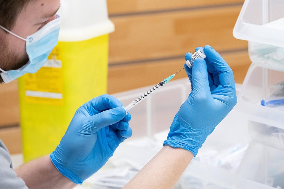 Ein Helfer zieht in einem Impfzentrum in Niedersachsen eine Biontech-Spritze auf: Mit einer speziellen Spritze lassen sich aus einer Ampulle des Stoffes sieben statt nur sechs Dosen aufziehen.
