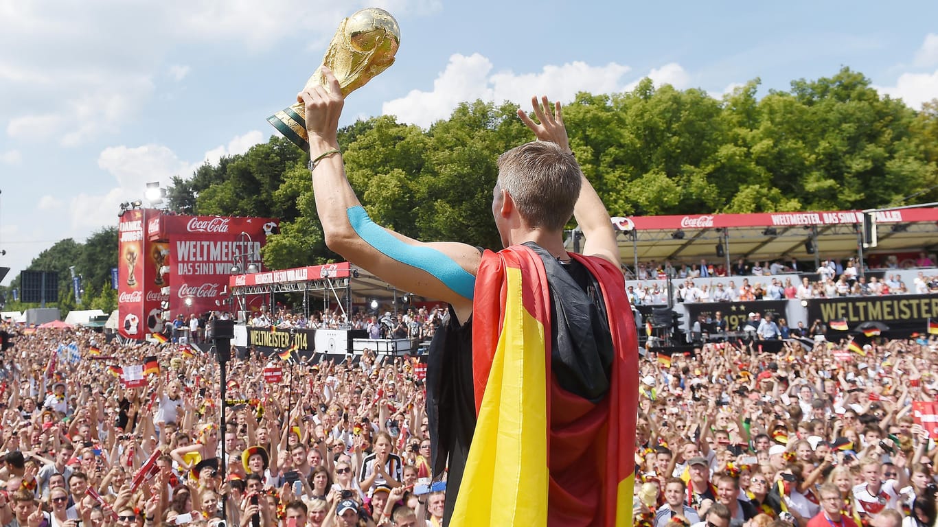 Deutschland mit Pokal und Deutschlandfahne bei der WM-Party: Dieses Jahr wird es keine Fanmeile geben.