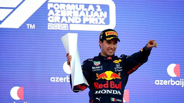 Der Mexikaner Sergio Perez vom Team Red Bull feiert seinen Sieg mit der Trophäe auf dem Podest. Der Mexikaner Sergio Perez vom Team Red Bull feiert seinen Sieg mit der Trophäe auf dem Podest.