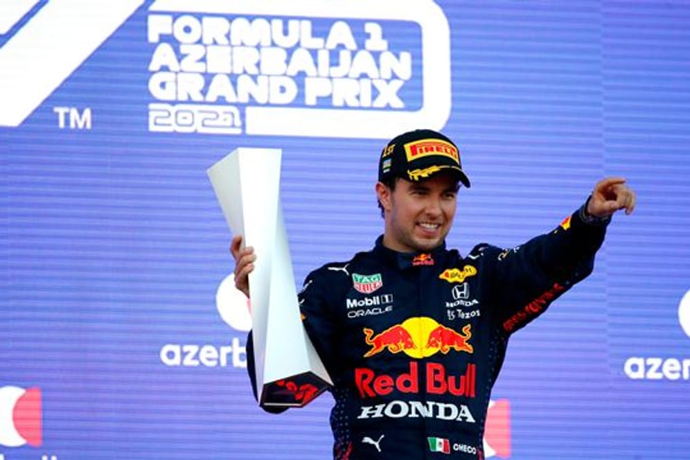 Der Mexikaner Sergio Perez vom Team Red Bull feiert seinen Sieg mit der Trophäe auf dem Podest.