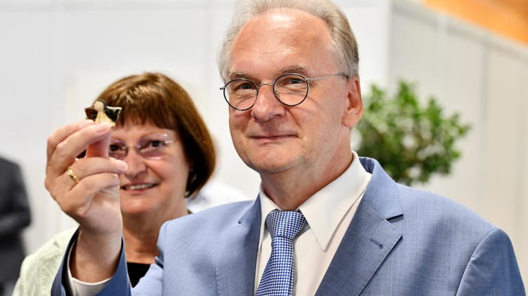 Reiner Haseloff zeigt seinen Glücksbringer: Der Ministerpräsident in Sachsen-Anhalt kann nach dem Wahlsieg die nächste Legislaturperiode planen.