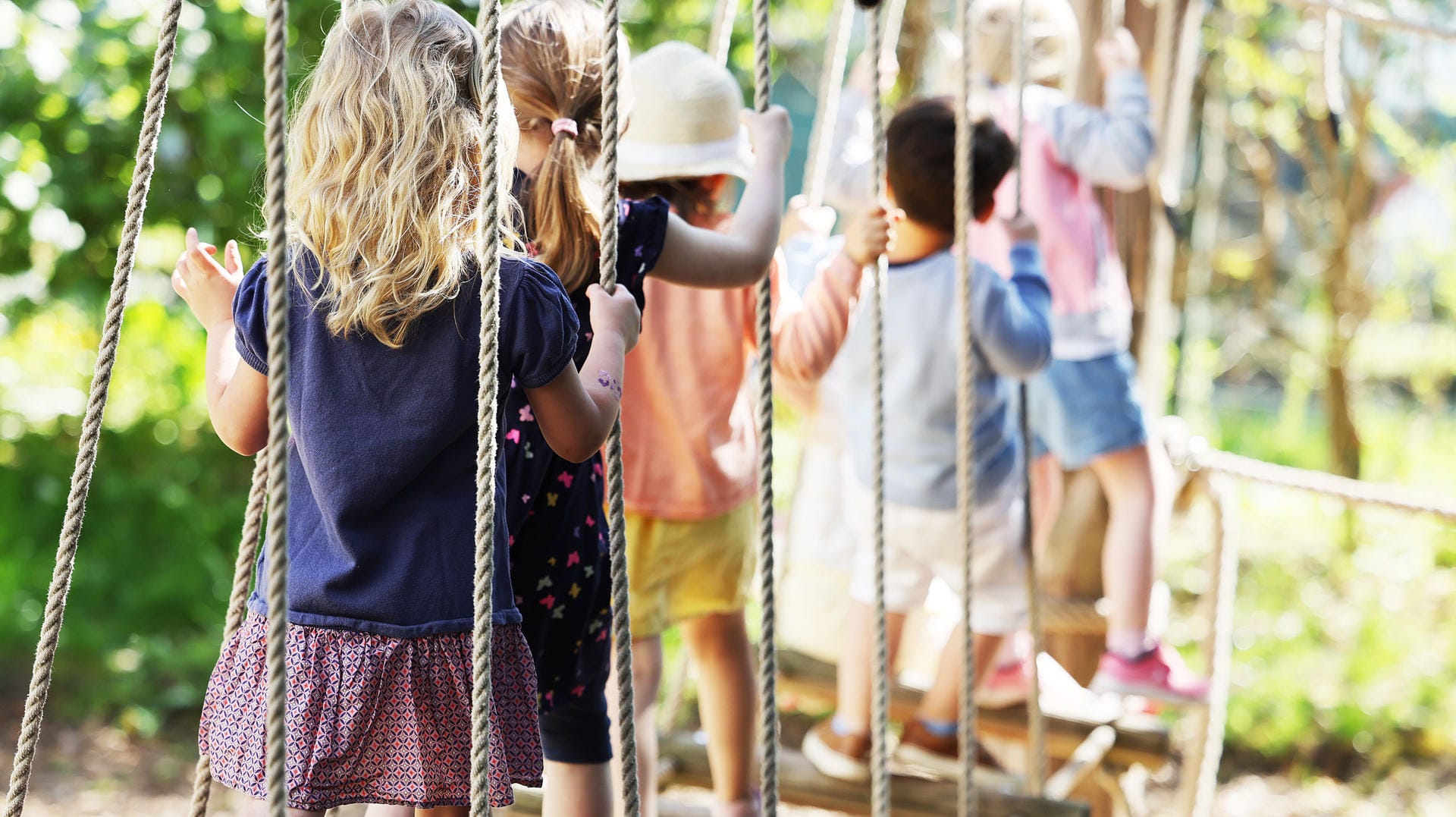 Kinder laufen in einer Kölner Kindertagesstätte über eine Hängebrücke: Kitas in NRW kehren in den Regelbetrieb zurück.