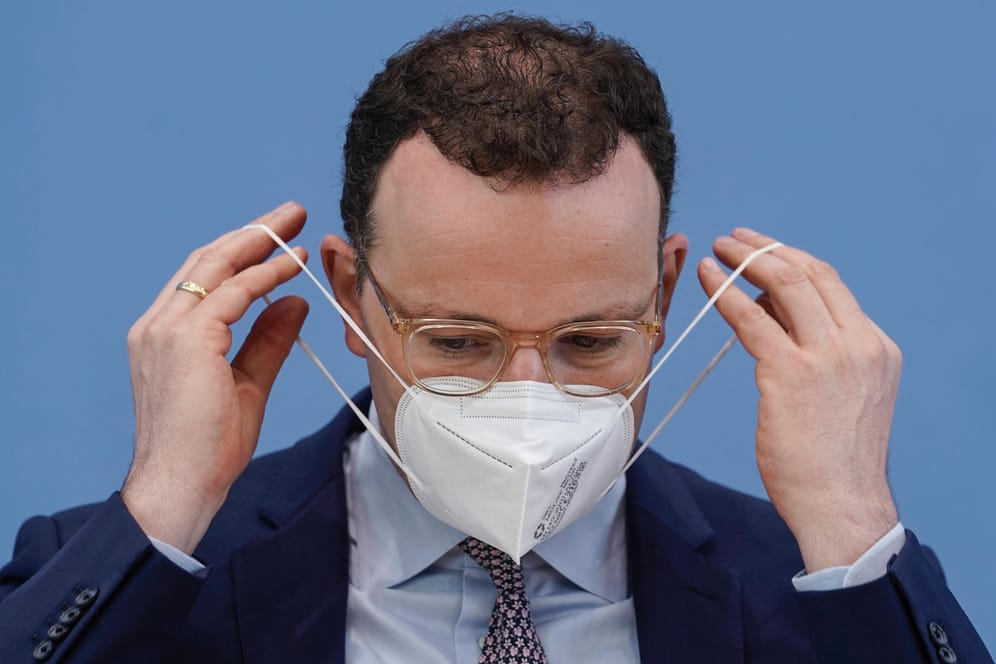Jens Spahn beim Anziehen einer Maske: Der Gesundheitsminister steht wegen eines erneuten Maskenskandals in der Kritik.