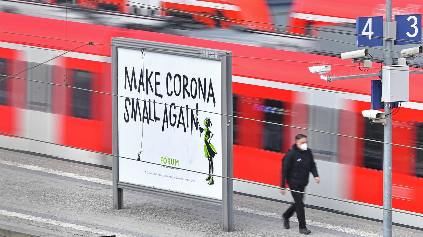 Themenbild Coronavirus Pandemie am 11.03.2021. Ein Werbeplakat auf einem Bahnsteig MAKE CORONA SMALL AGAIN, einfahrende