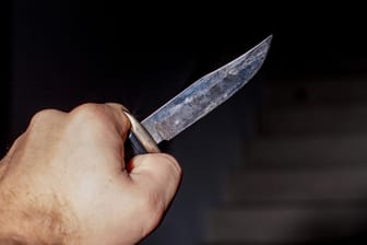 Ein Mann hält ein Messer in der Hand (Symbolbild): In Mülheim hat ein Unbekannter einen Kiosk überfallen.