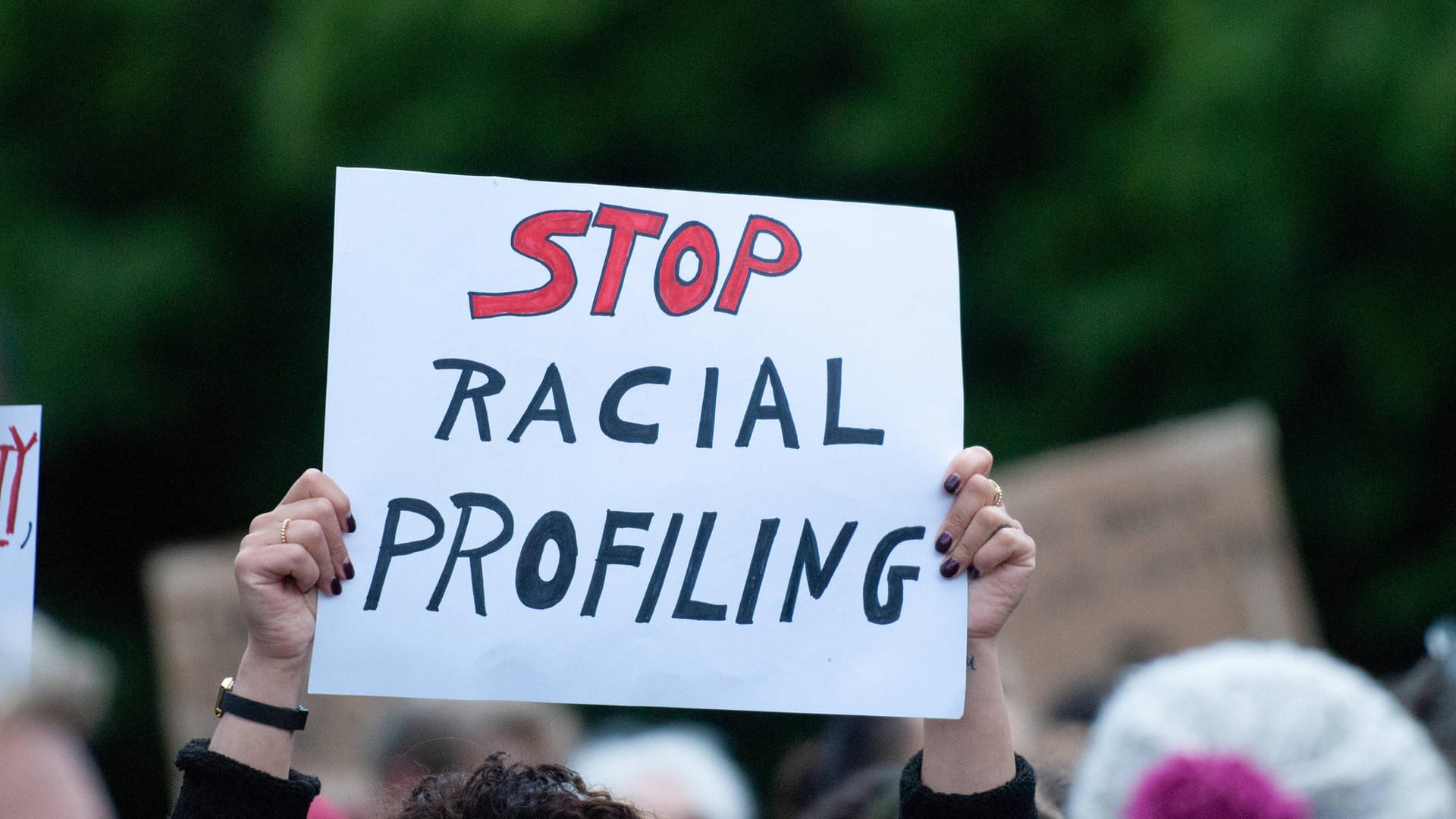 Eine Person hält ein Schild mit der Aufschrift "Stop Racial Profiling" (Symbolbild): Durch das Gesetz können sich Personen beschweren, wenn sie sich von Behörden diskriminiert fühlen.