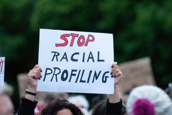 Eine Person hält ein Schild mit der Aufschrift "Stop Racial Profiling" (Symbolbild): Durch das Gesetz können sich Personen beschweren, wenn sie sich von Behörden diskriminiert fühlen.