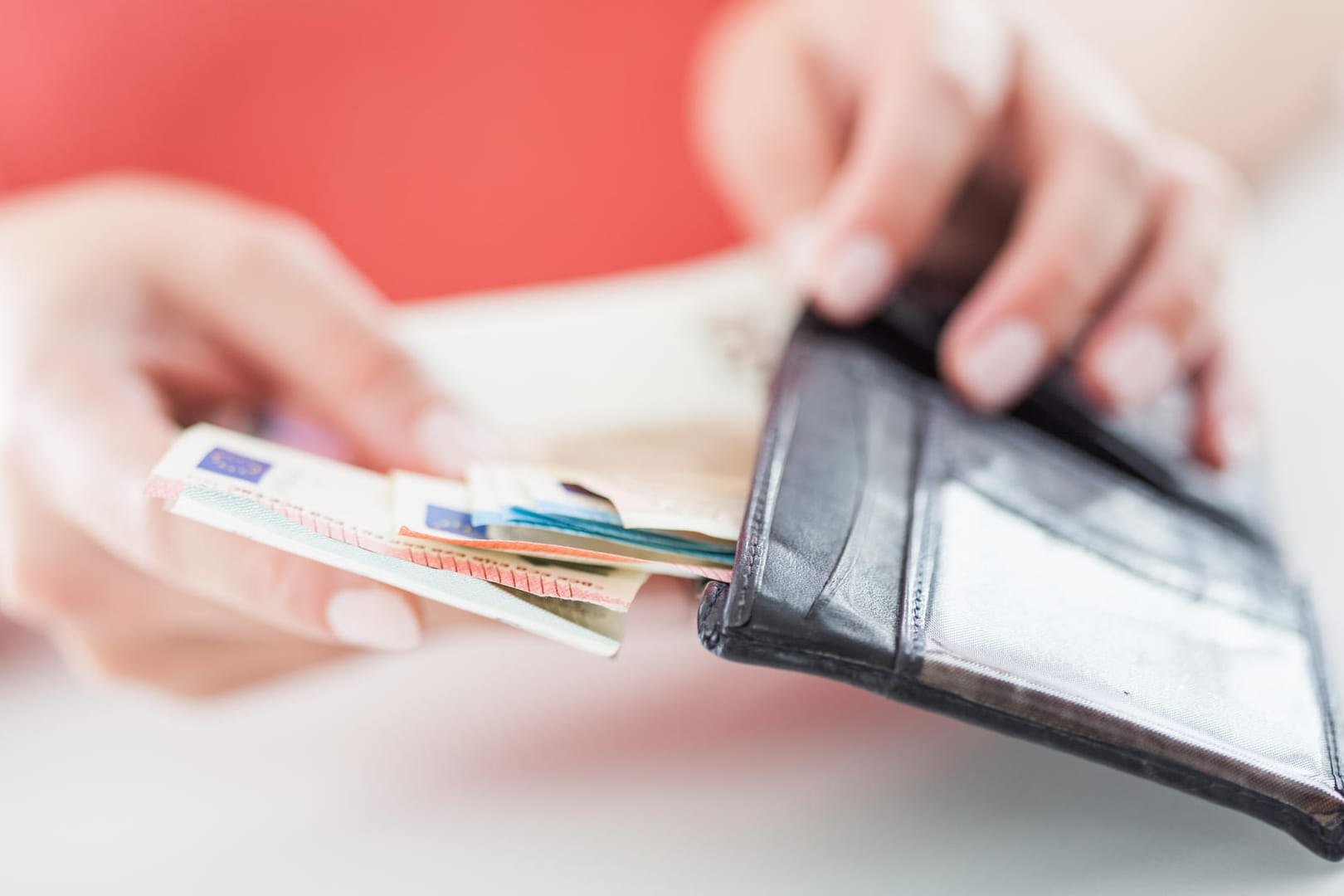 Eine Frau öffnet ihr Portemonnaie (Symbolbild): Die Lohnquote soll angeben, wie das Einkommen in Deutschland verteilt ist.