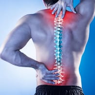 Körperrückseite eines Mannes mit Rückenschmerzen: Verspannungen im Bereich des Nackens und der Wirbelsäule können in Stress ihren Ursprung haben.