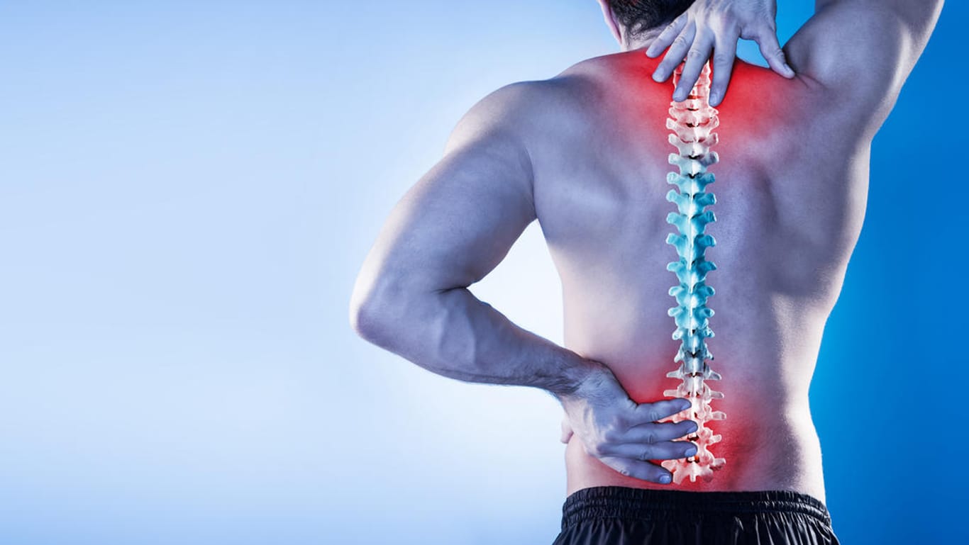 Körperrückseite eines Mannes mit Rückenschmerzen: Verspannungen im Bereich des Nackens und der Wirbelsäule können in Stress ihren Ursprung haben.
