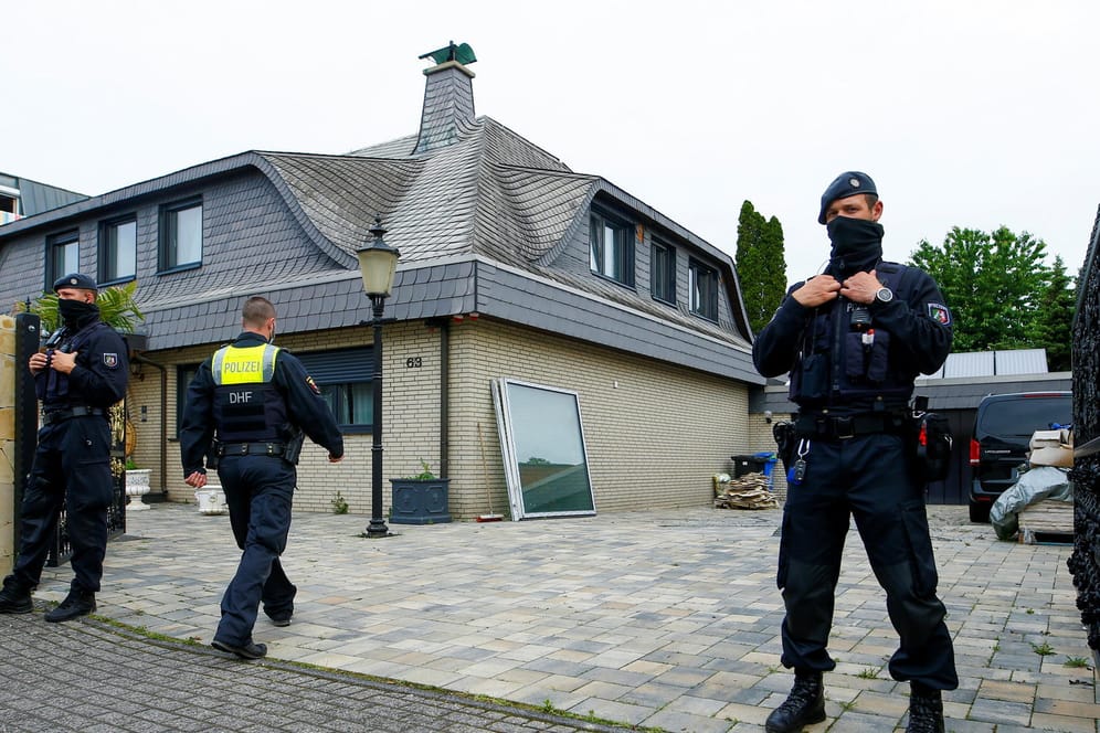 Polizisten stehen vor einer Villa: Dort wohnte eine Familie, die als Sozialhilfeempfänger registriert gewesen sein soll.