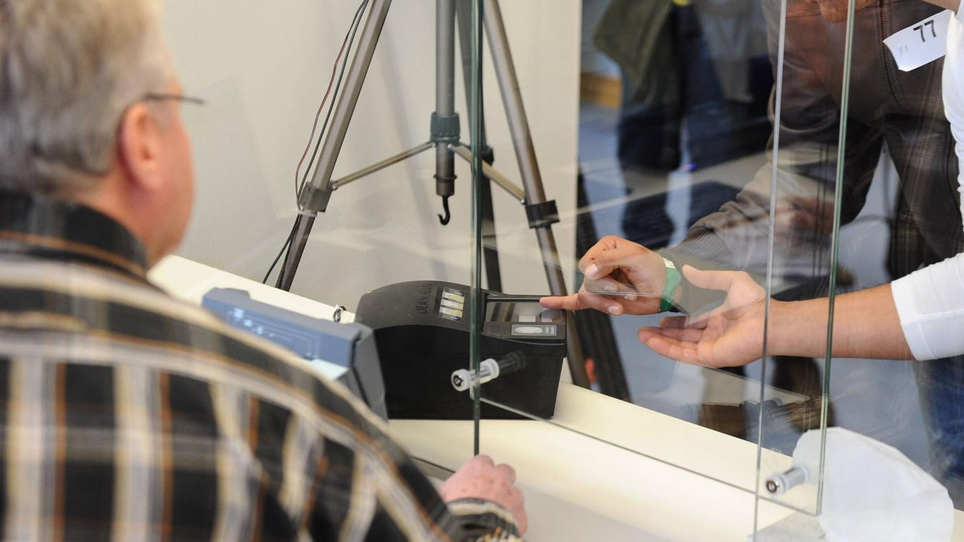 Ein Asylsuchender lässt in einer Erstaufnahmestelle in Heidelberg seinen Fingerabdruck scannen (Symbolbild): In 2021 sind erstmals seit Jahren wieder mehr Geflüchtete in Rheinland-Pfalz aufgenommen worden.