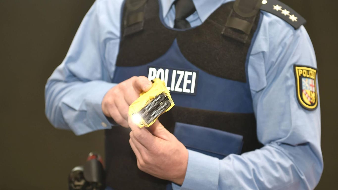 Ein Polizeibeamter demonstriert ein Distanzelektroimpulsgerät: Eine solche Waffe setzten Polizisten in Düsseldorf am Wochenende ein.