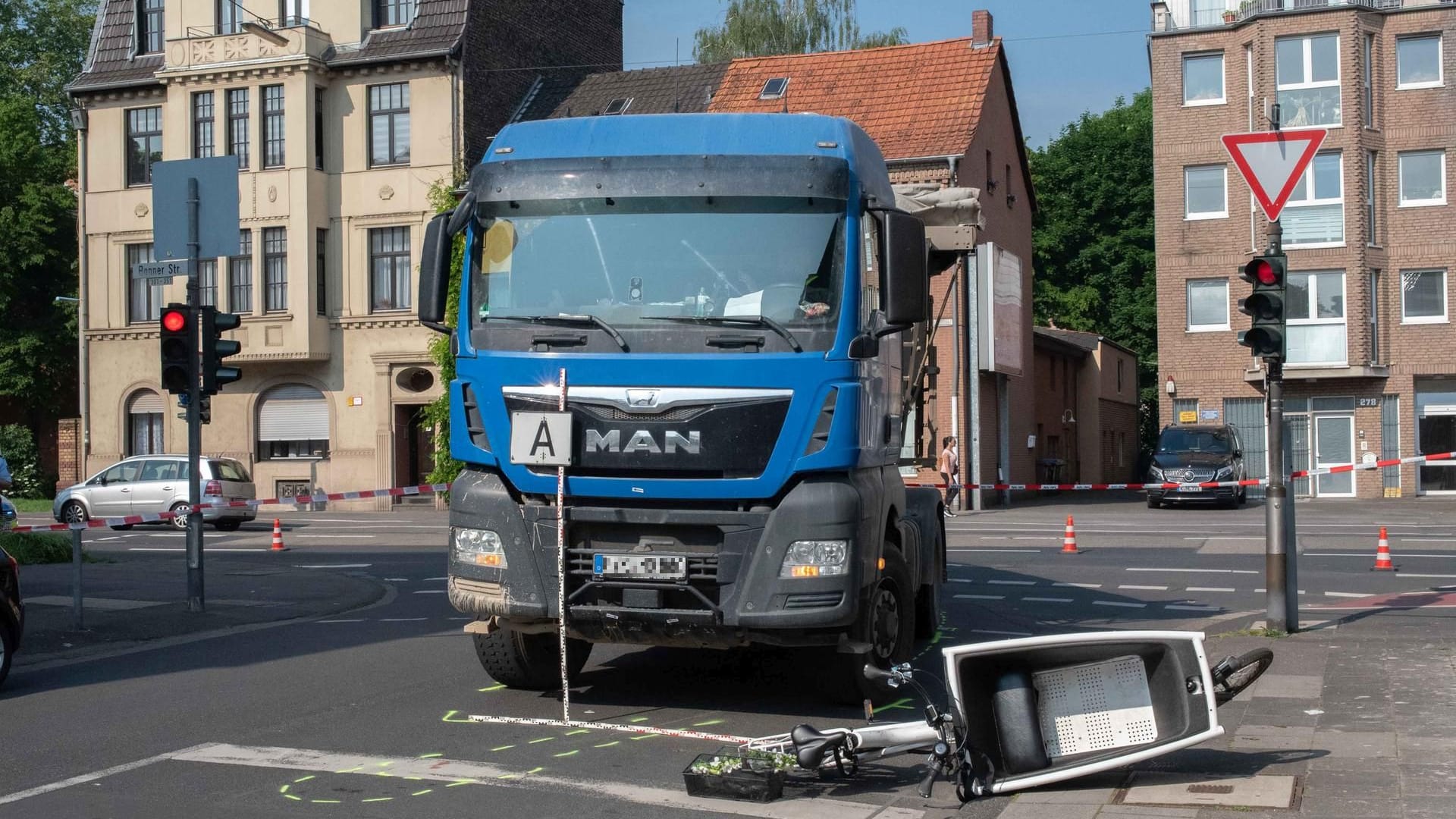 Das Lastenfahrrad liegt vor dem Kipplaster: Eine Frau wurde bei einem Unfall in Köln-Bayenthal von einem Lkw mitgeschleift und dabei schwer verletzt. Das Lastenfahrrad liegt vor dem Kipplaster: Eine Frau wurde bei einem Unfall in Köln-Bayenthal von einem Lkw mitgeschleift und dabei schwer verletzt.