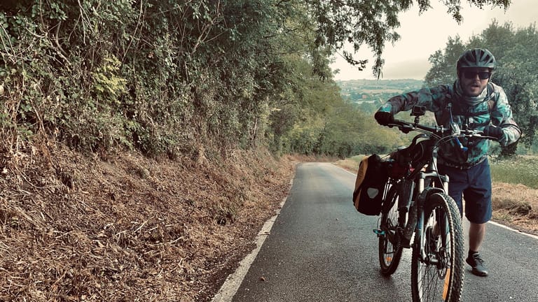 Fabio Beinhofer schiebt sein Fahrrad einen Berg hoch: Die Radtour war nicht immer einfach.